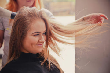 Woman using professional-grade hair straightener at home while practicing essential beauty tips for stunning strands